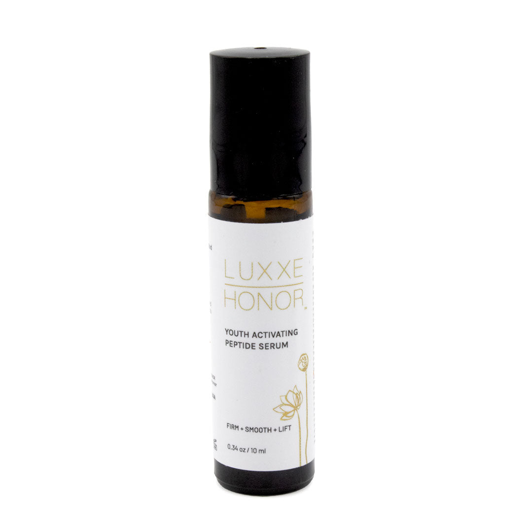A brown glass bottle containing serum sits on a white background.  The bottle is topped with a black rollerball applicator.  The label reads: LUXXE HONOR, YOUTH ACTIVATING PEPTIDE SERUM, FIRM + SMOOTH + LIFT, 0.34 oz/10 ml.